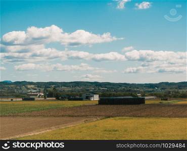 Mountain and rice fields with blue sky and clouds in Hokkaido, Japan. Nature landscape.
