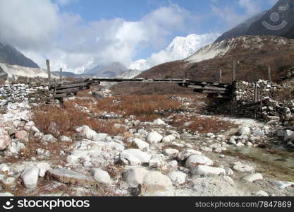 Mountain and wooden bridge on the river in Nepal