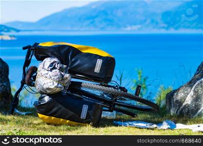 Mountain bicycle with attached bag saddlebag against nature, mountains fjord landscape in Norway. Bike with saddlebag on nature, Norway
