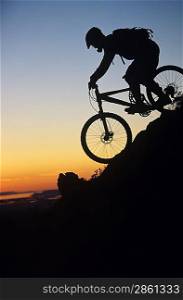 Mountain biker riding down slope