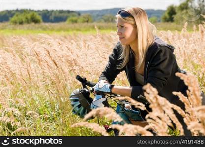 Mountain biking happy young woman relax in cornfield sunny countryside
