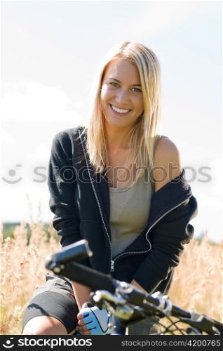 Mountain biking happy young woman relax in cornfield sunny countryside