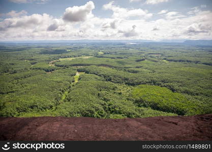 Mountain by green grass and cloudy blue sky