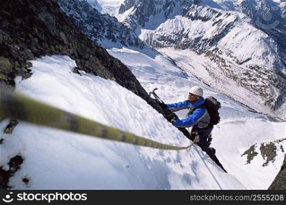 Mountain climber going up snowy mountain