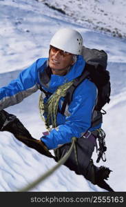 Mountain climber going up snowy mountain (selective focus)