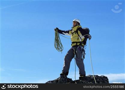 Mountain climber standing on top of mountain (selective focus)