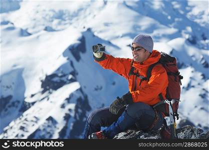 Mountain climber taking a picture on mountain peak