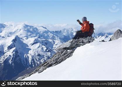 Mountain climber taking picture on mountain peak