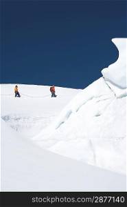 Mountain climbers walking past ice formation