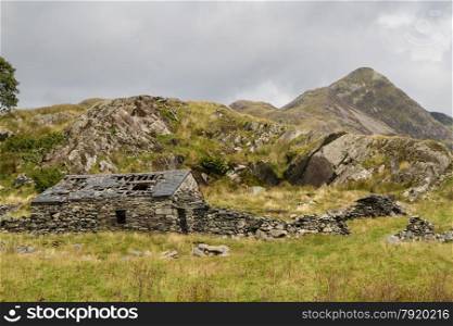 Mountain Cnicht in Croesor Valley, Snowdonia. Derelict stone cottage or farmhouse in foreground.