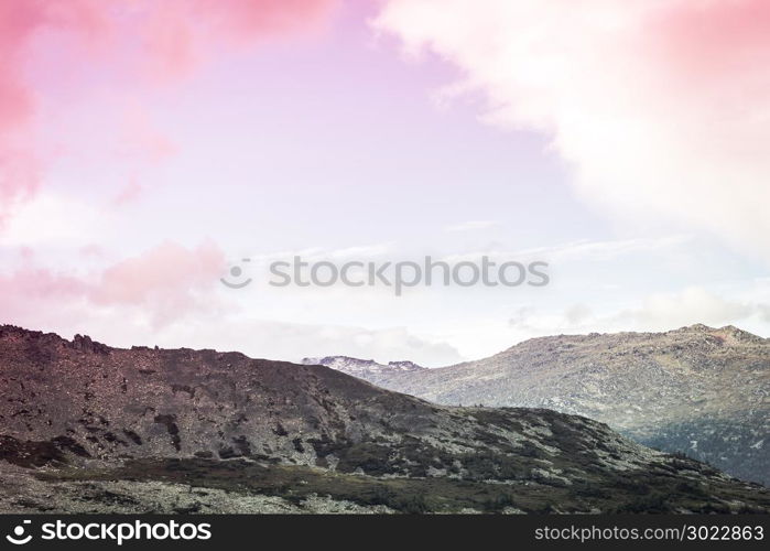 Mountain country under the pastel pink sky. A romantic trip to the mountains. The beauty of nature, dawn over the hills.