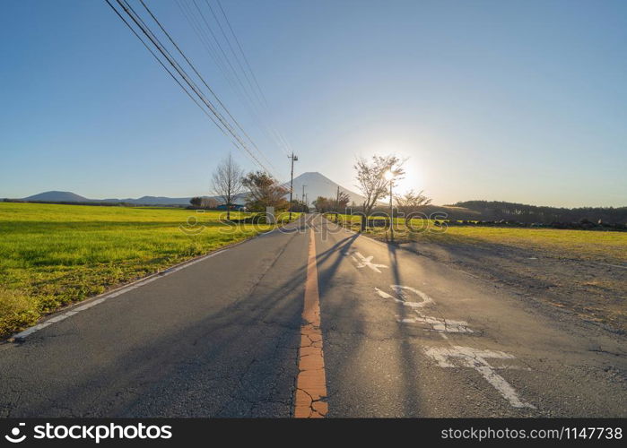 Mountain Fuji and street road with blue sky near Fuji Five Lakes, Fujikawaguchiko, Yamanashi, Japan. Nature landscape background.