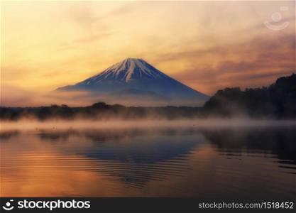 Mountain Fuji with skyline reflection and mist on water of lake Shoji Shojiko at sunrise, Yamanashi, Japan. Famous travel 5 lakes to see mount Fujisan.