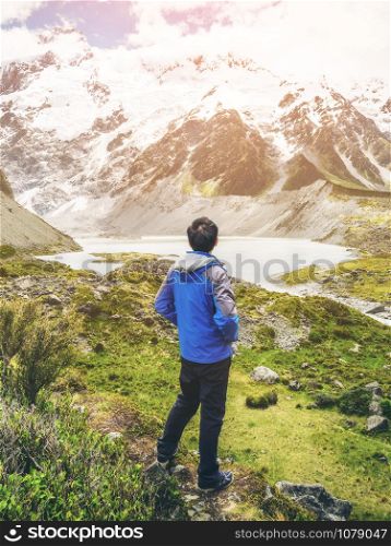 Mountain hiker traveling in wilderness landscape of Mt Cook National Park. Mt Cook, the highest mountain in New Zealand, is known for outdoor travel trekking inspiration, mountain journey.