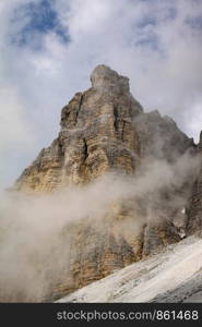 Mountain in Dolomites with clouds and fog