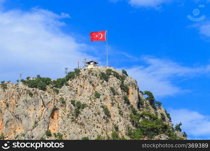 Mountain in Kemer and the Turkish flag against the blue sky