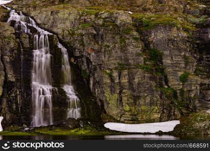 Mountain lake Flotvatnet with waterfall. Scenic region between Aurland and Laerdal in Norway. National tourist route Aurlandsfjellet.. Mountain lake waterfall Flotvatnet Norway