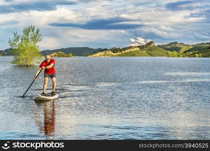 mountain lake landscape with a senior male paddling a SUP paddleboard with a copy space - Horsetooth Reservoir, Fort Collins, Colorado