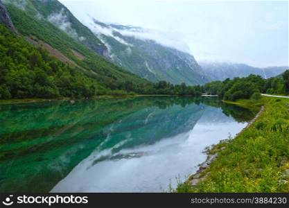 Mountain lake with clean water (Norway, near Stordal). Summer cloudy view.