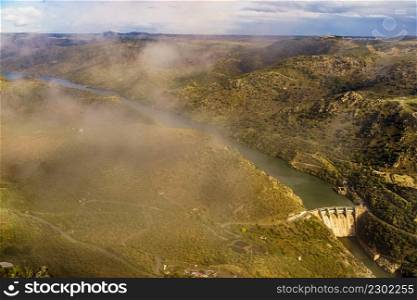 Mountain landscape and Douro river with spanish Saucelle Dam. Border between Portugal and Spain. National Park. View from portuguese Penedo Durao lookout.. Douro river with Saucelle Dam. Border Spain Portugal