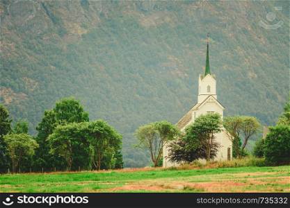 Mountain landscape and the white wooden Oppstryn Church in Stryn Municipality in Sogn og Fjordane county, Norway.. Oppstryn Church in Norway
