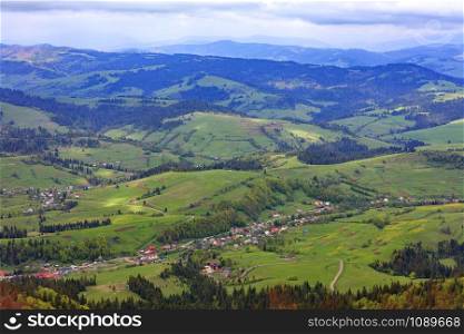 Mountain landscape with a view of the village and ski lift in the spring from a mountain peak, nature in the Carpathian mountains.. Beautiful landscape of the Carpathian mountains, Ukraine. View of the village from the top of the mountain.
