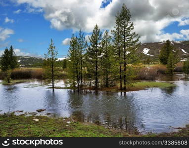 mountain landscape with river and trees against a cloudy sky