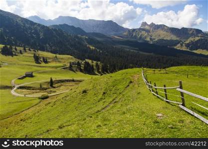 Mountain landscape with wooden fence, shelter and hiking trails