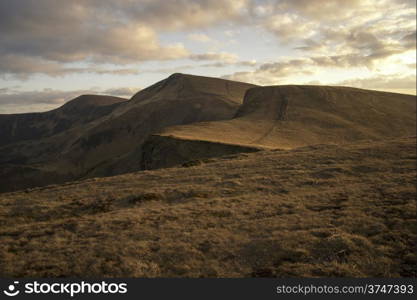 Mountain peaks in the autumn evening sky with clouds