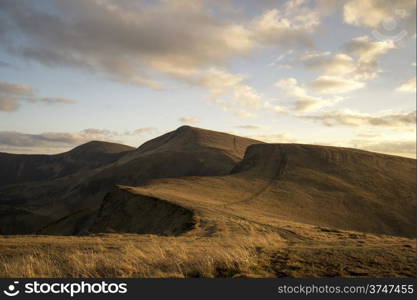 Mountain peaks in the autumn evening sky with clouds