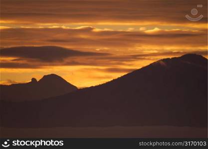Mountain Range Silhouetted By A Golden Sunset