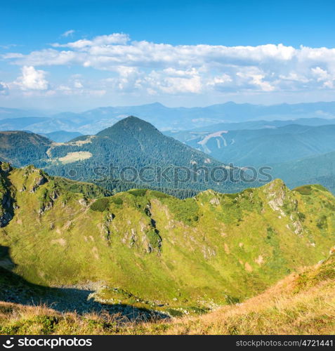 Mountain range with dry yellow grass and blue sky