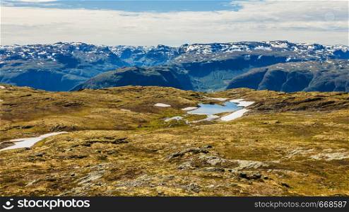 Mountain region between Aurland and Laerdal in Norway. Rocky landscape with snow peaks in distance. National tourist scenic route Aurlandsfjellet.. Mountains landscape. Norwegian scenic route Aurlandsfjellet