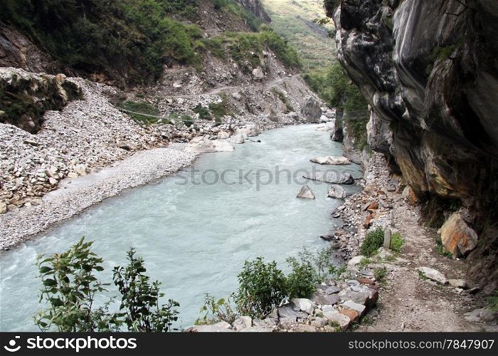 Mountain river and rocky footpath near Tal, Nepal