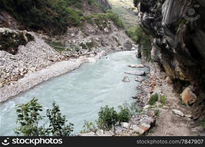 Mountain river and rocky footpath near Tal, Nepal
