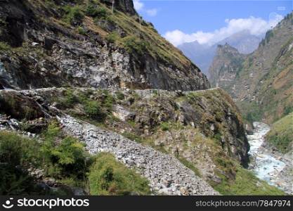 Mountain river and rocky road on the Annapurna trail in Nepal