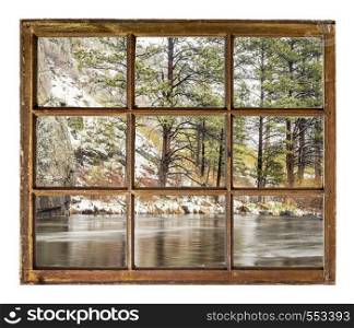 mountain river canyon in early spring after snowstorm as seen through a vintage sash window