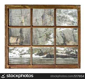 mountain river canyon in spring snowstorm as seen through vintage sash window