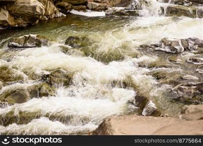 Mountain river in a beautiful winter green coniferous forest on the slopes of the mountains. Outdoor recreation in the winter season