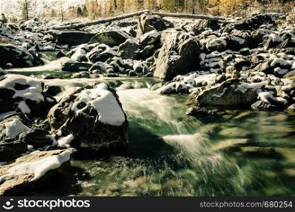 Mountain river in winter. Cold water flows among rocks. Journey onriver in mountains.