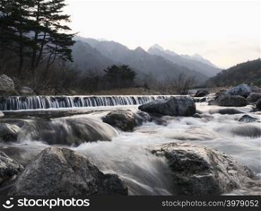 Mountain river. Water on river rapids. Photo on exposure