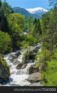 Mountain river with waterfall flows in green forest. Caucasus mountains spring landscape. Mountain river with waterfall flows in green forest. Caucasus mountains spring landscape.