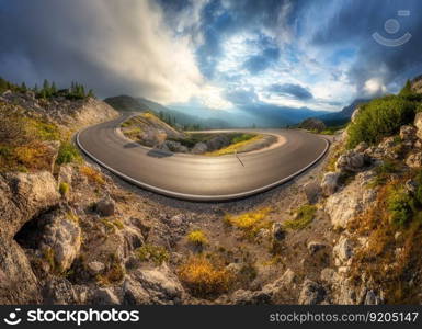 Mountain road at colorful sunset in summer. Dolomites, Italy. Beautiful curved roadway, rocks, stones, blue sky with clouds. Landscape with empty highway through the mountain pass in spring. Panorama