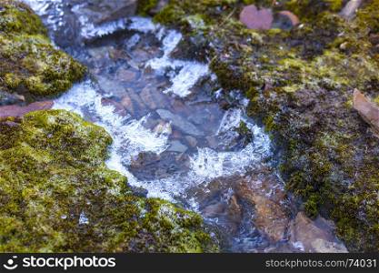 mountain trickle with ice after night frosts in autumn