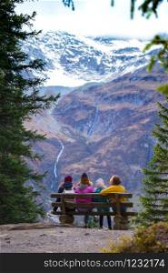 mountain trip. family in the mountains sits on a bench and looks at the mountains