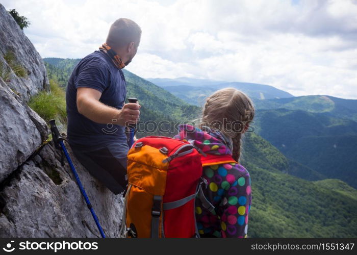 mountain trip. Family standing at the edge of rock