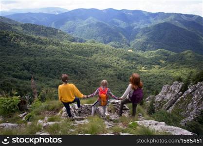 mountain trip. Family standing at the edge of rock