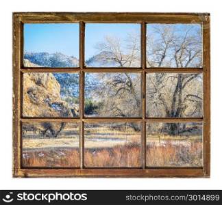 mountain valley with pastures as seen through vintage, grunge, sash window with dirty glass