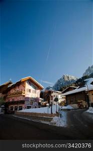 Mountain Village In Italian Alps Against Blue Clear Sky