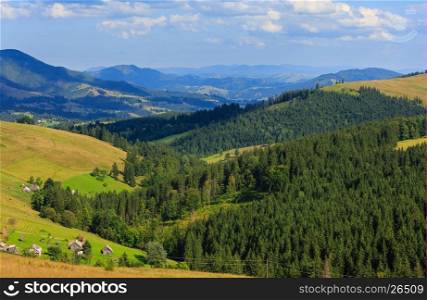 Mountain village. Summer country landscape with fir forest on slope (Carpathian, Ukraine, Verkhovyna district, Ivano-Frankivsk region).